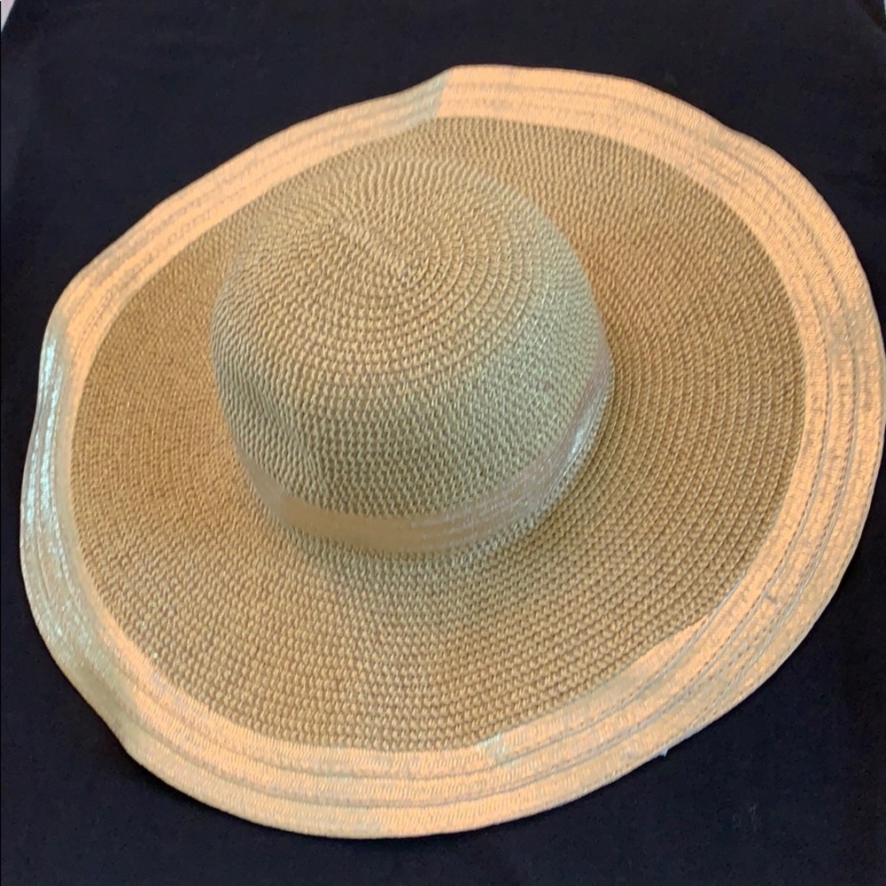 Straw hat with gold ribbon attached around brim